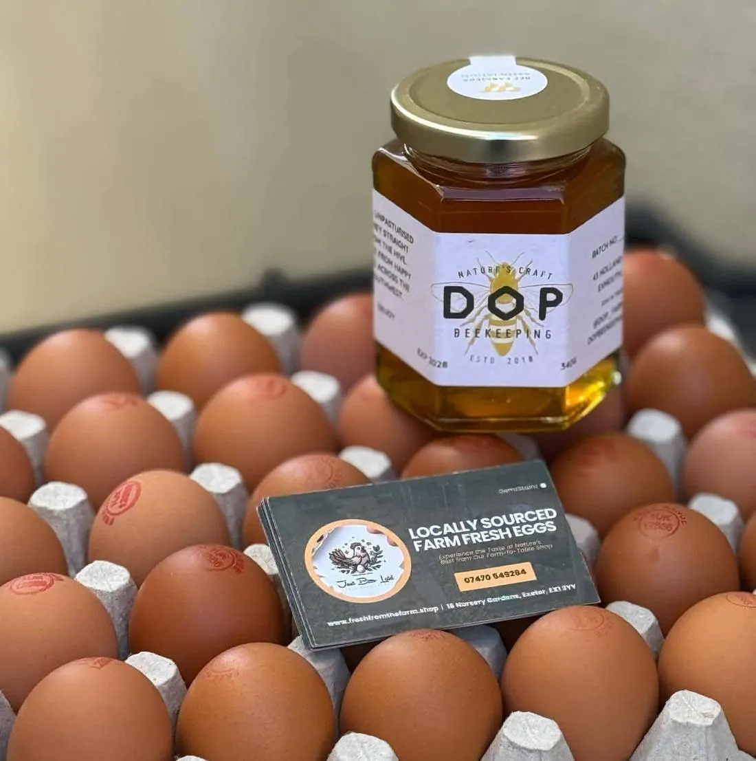 Trays of UK-stamped free-range eggs with a jar of DOP raw honey — Just Been Laid produce